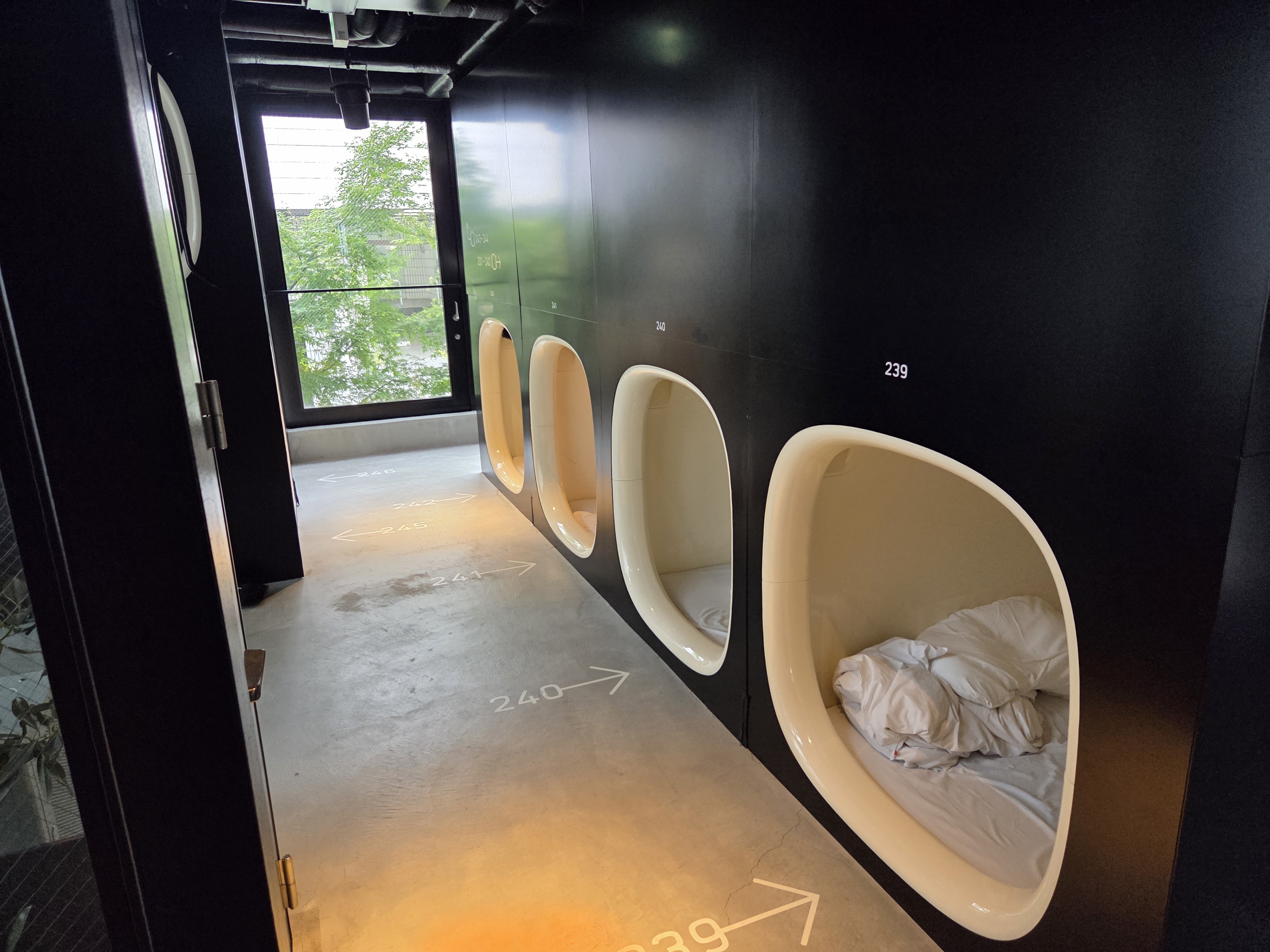 Sleeping pods lining a capsule-hotel corridor in Tokyo
